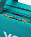 Close-up of Yonex Pro Tournament Bag BA92431W in Dark Green showing multiple zippered storage compartments and contrasting orange zipper pulls