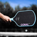 Six Zero Coral Lightweight Hybrid in Misty Blue, paddle held on court