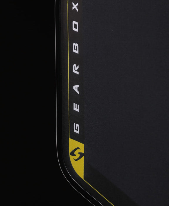 Close-up of the Pressure X 8E textured carbon face, yellow outline and Gearbox logo