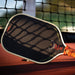LOCO Elongated Tan paddle face close-up with cream edge and net shadows on court