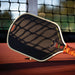 LOCO Hybrid Tan paddle face close-up with cream edge and net shadows on court